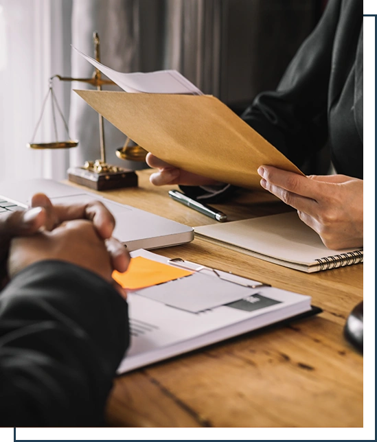 Business and lawyers discussing contract papers with brass scale on desk in office.