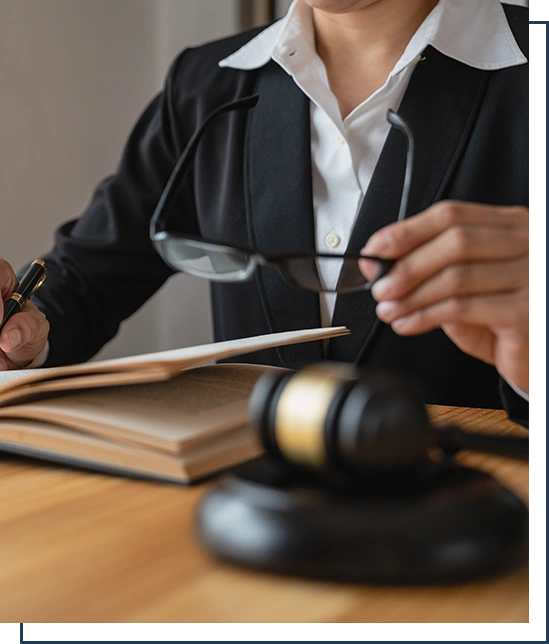 Asian female lawyer or legal consultant working in the justice level sits at her desk holding a pen and removing glasses to relax looking detailed