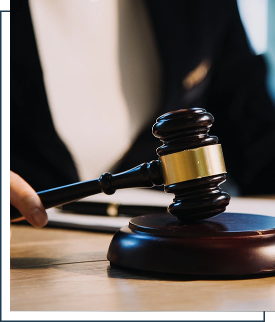 Male judge in a courtroom with the gavel, working with, computer and docking keyboard, eyeglasses, on table in morning light