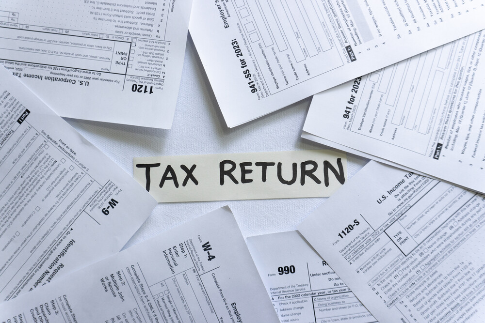 Different tax return forms on the table. Tax Return written in the middle